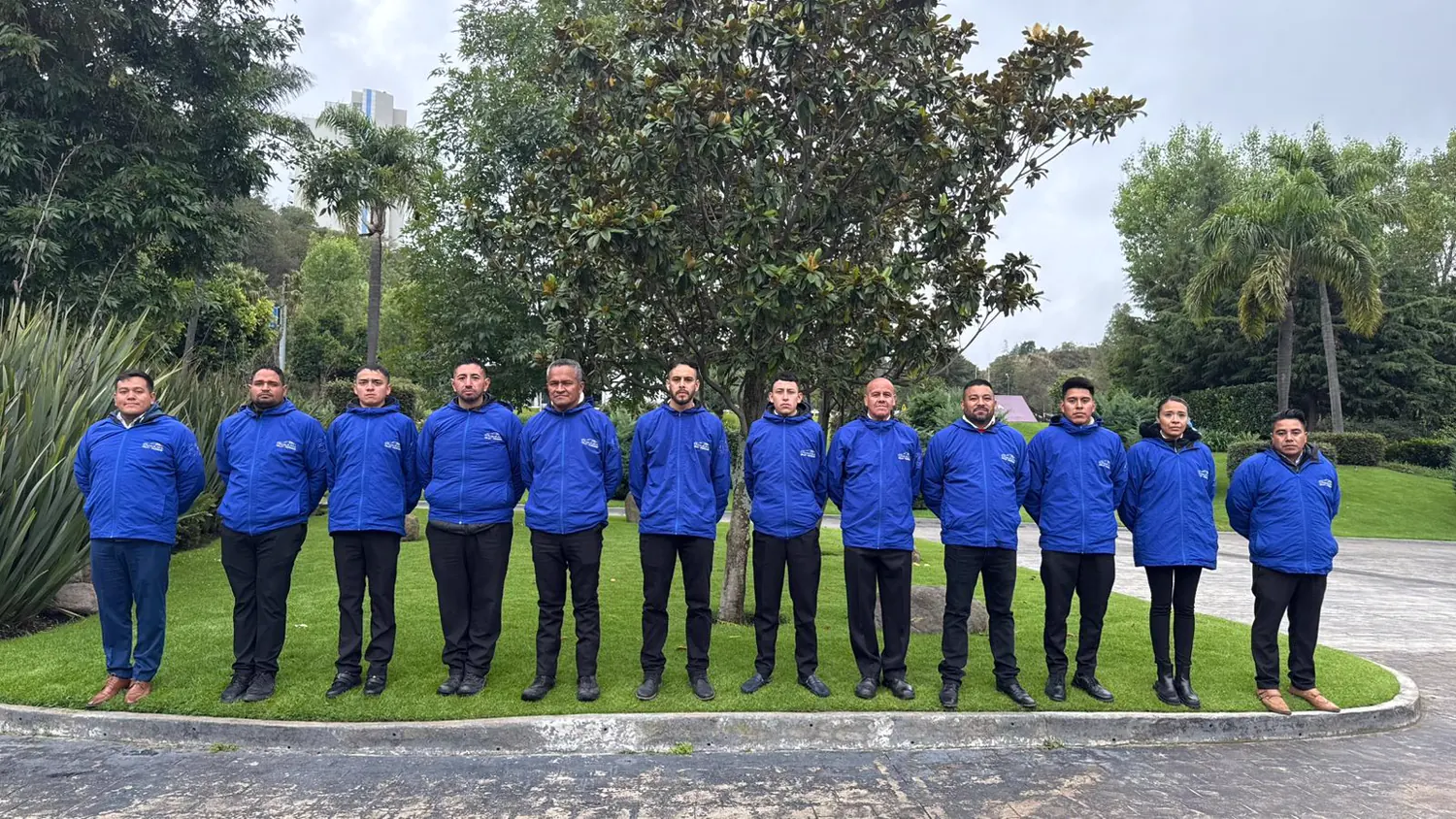 Equipo operativo con chaquetas azules formado en un jardín