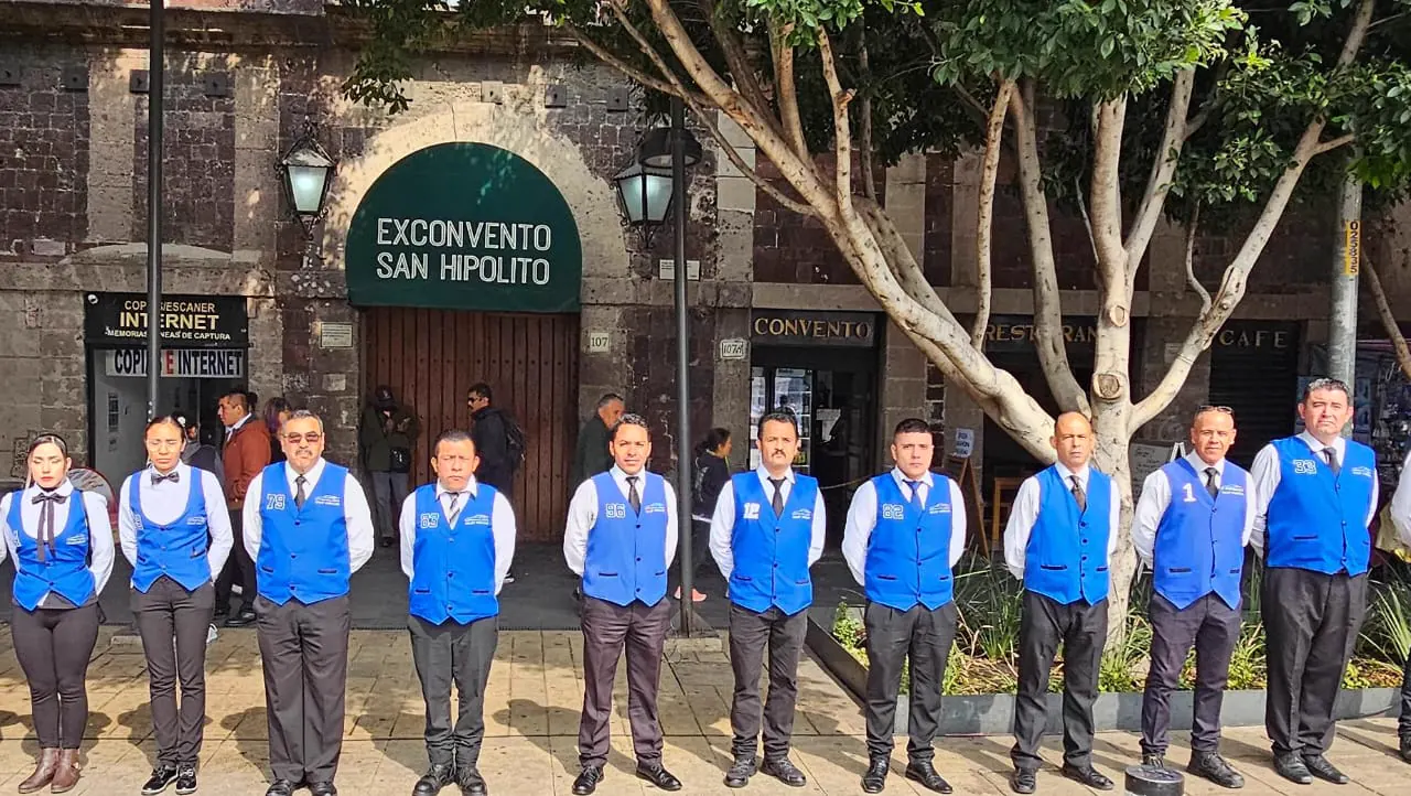 Equipo de valet uniformado frente al acceso de un recinto durante el día